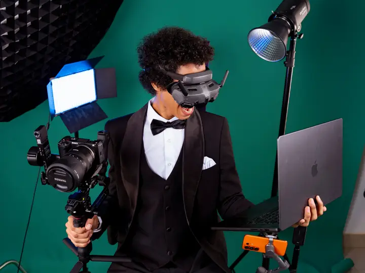 Mister H, casque FPV sur les yeux, entouré de son matériel de tournage