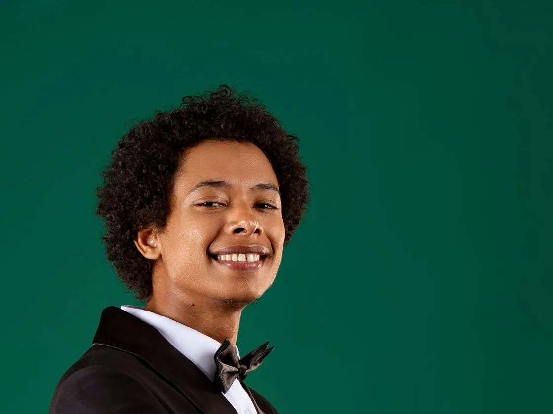 Portrait studio souriant, en costume sur fond vert — filière Photographie